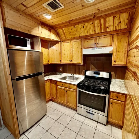 a kitchen with stainless steel appliances granite countertop a stove and a refrigerator