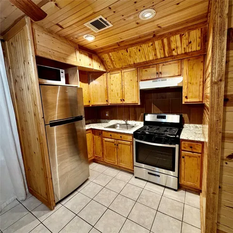 a kitchen with stainless steel appliances granite countertop a stove and a refrigerator