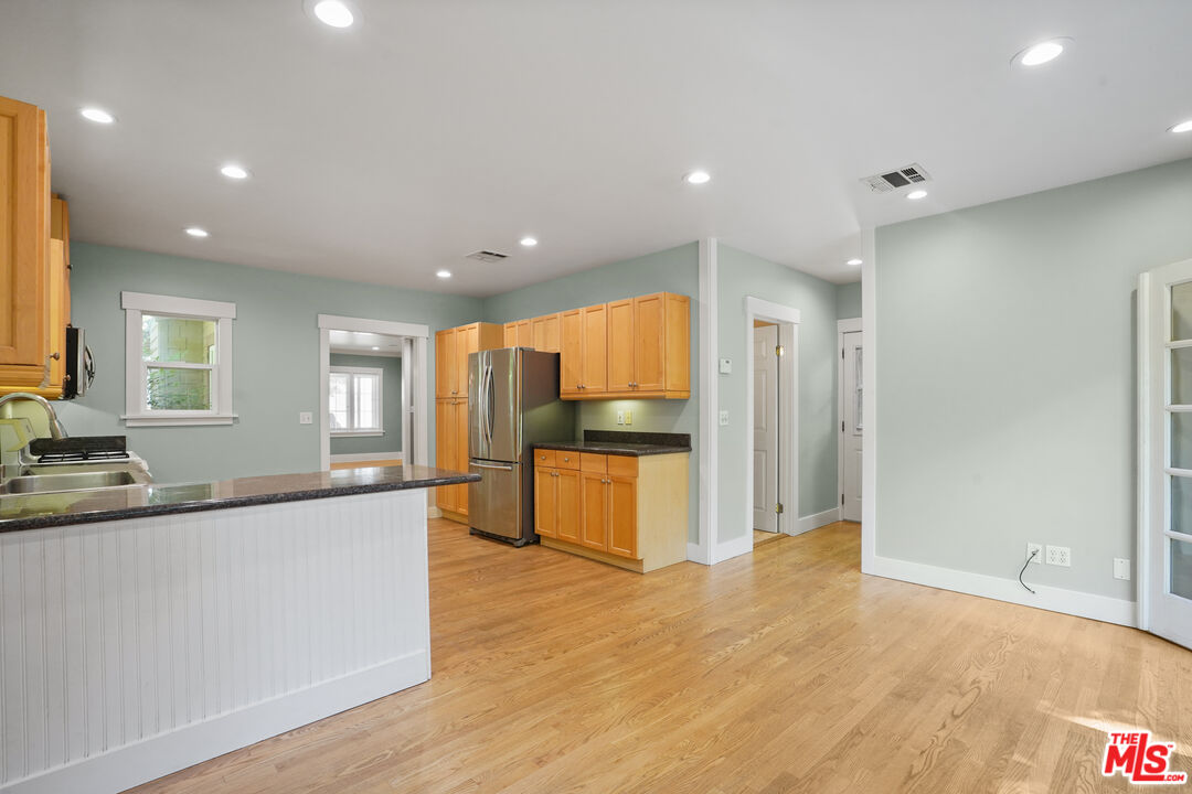 910 Bell Street Pasadena, CA 91104 - Photo 9 of 32 a large kitchen with stainless steel appliances granite countertop a large counter top a stove and a refrigerator