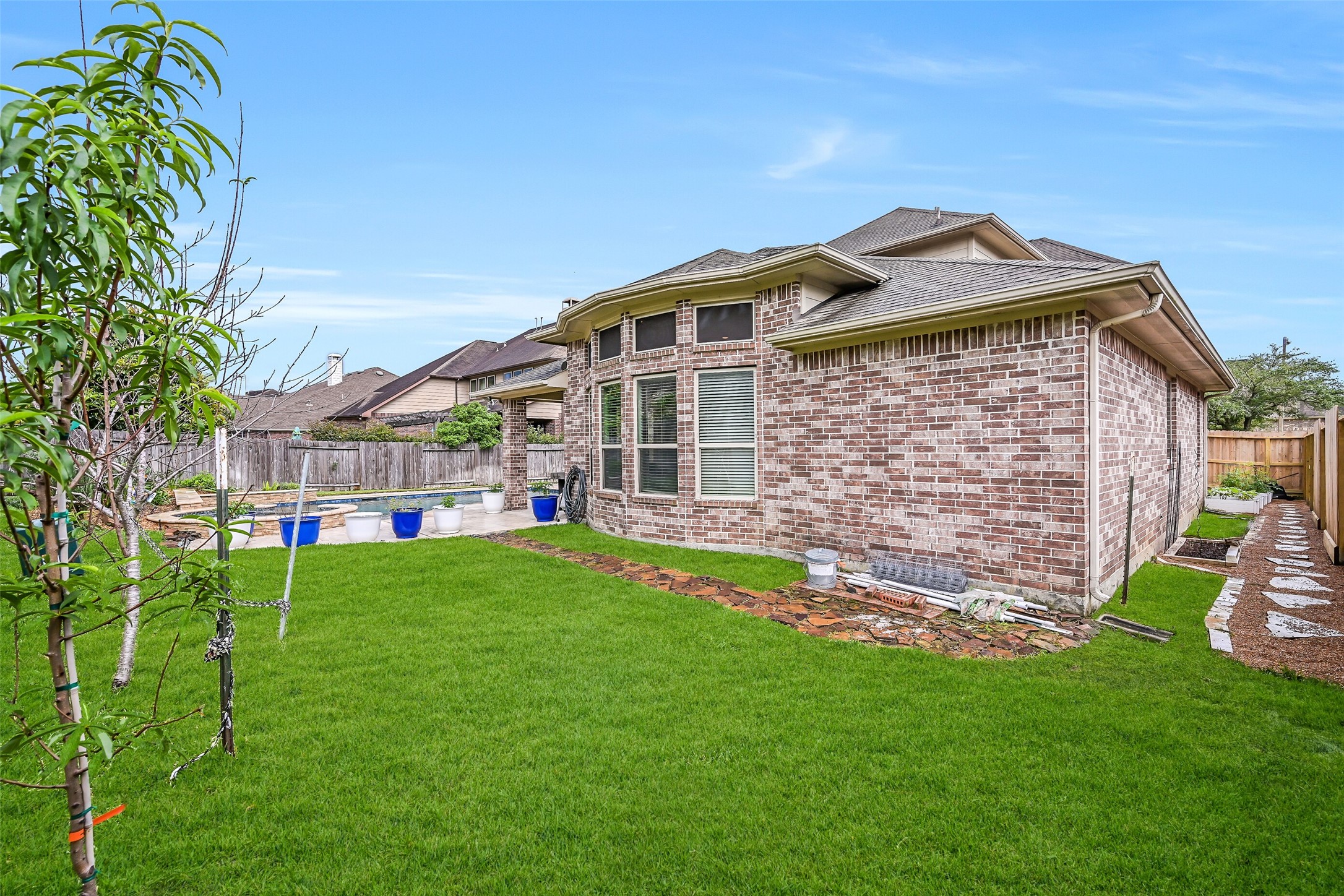 1008 Point Isabel Lane Friendswood, TX 77546 - Photo 50 of 50 One last glance at the backyard at 1008 Point Isabel highlights the raised garden beds tucked along the side of the home, the lush play space for kids or pets to run, along with the resort-quality pool and spa. This one is worth a look in person!