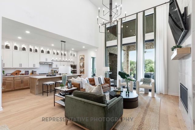 a living room with furniture kitchen view and a large window