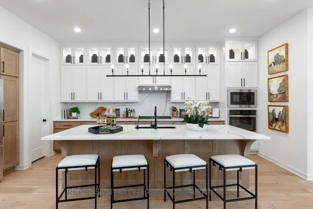 a kitchen with granite countertop white cabinets and stainless steel appliances