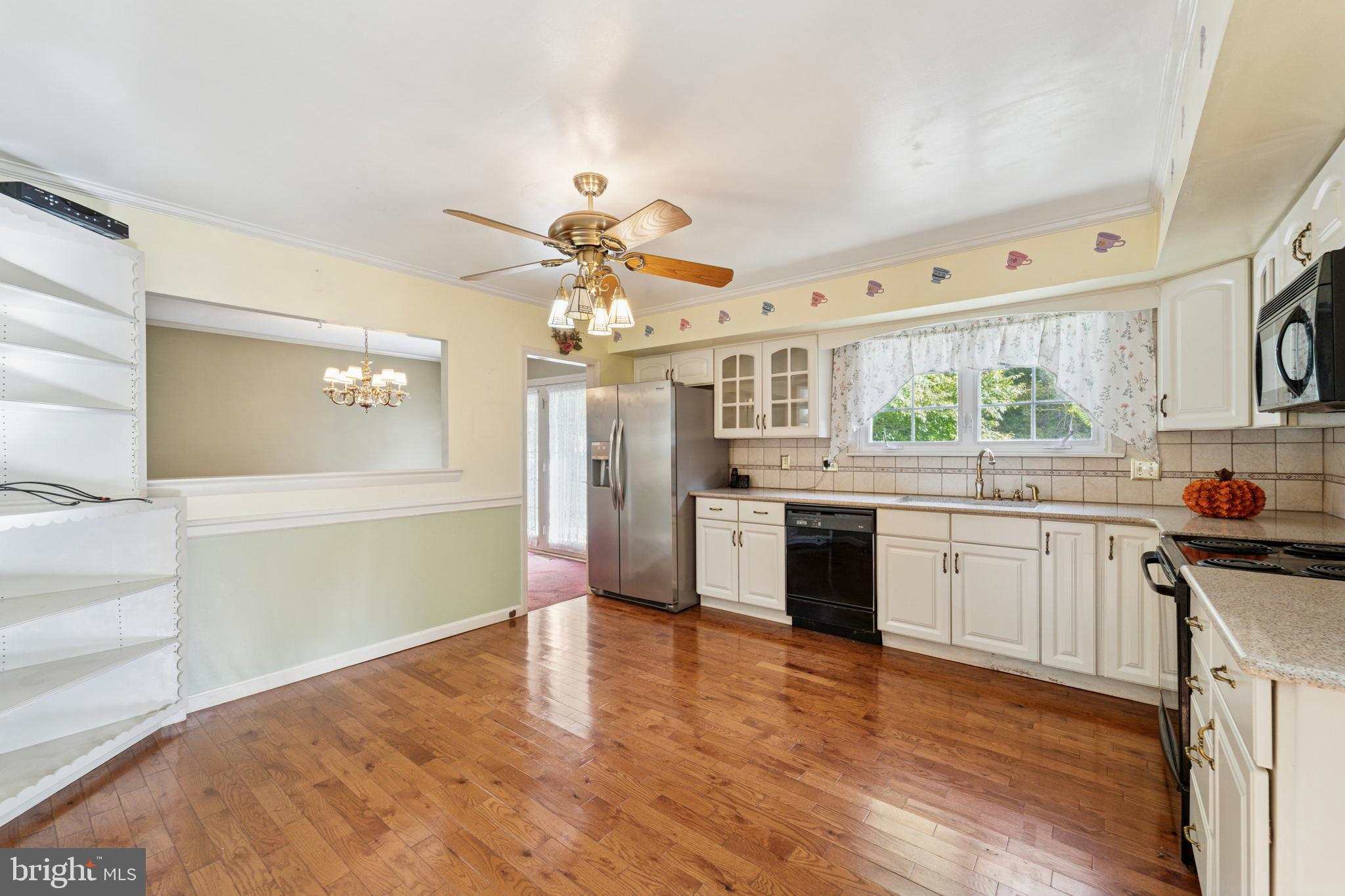 505 Schick Road Aston, PA 19014 - Photo 8 of 17 a kitchen with stainless steel appliances kitchen island granite countertop a refrigerator a stove a sink dishwasher and white cabinets with wooden floor