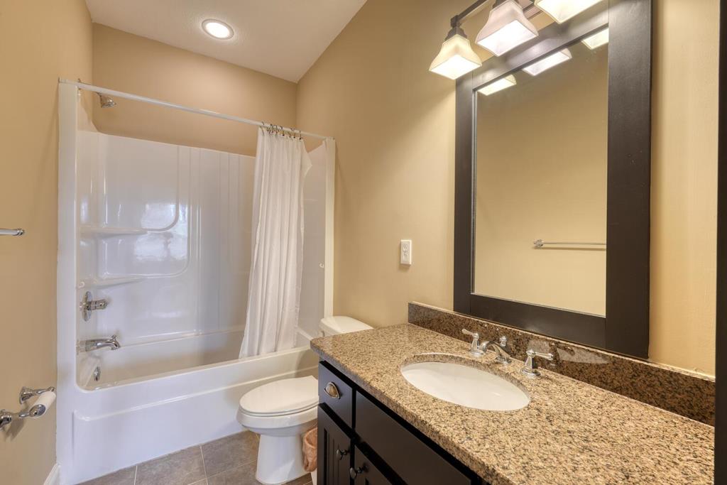 1401 Lakeside Road Hiawassee, GA 30546 - Photo 21 of 46 a bathroom with a granite countertop sink toilet mirror and a bathtub