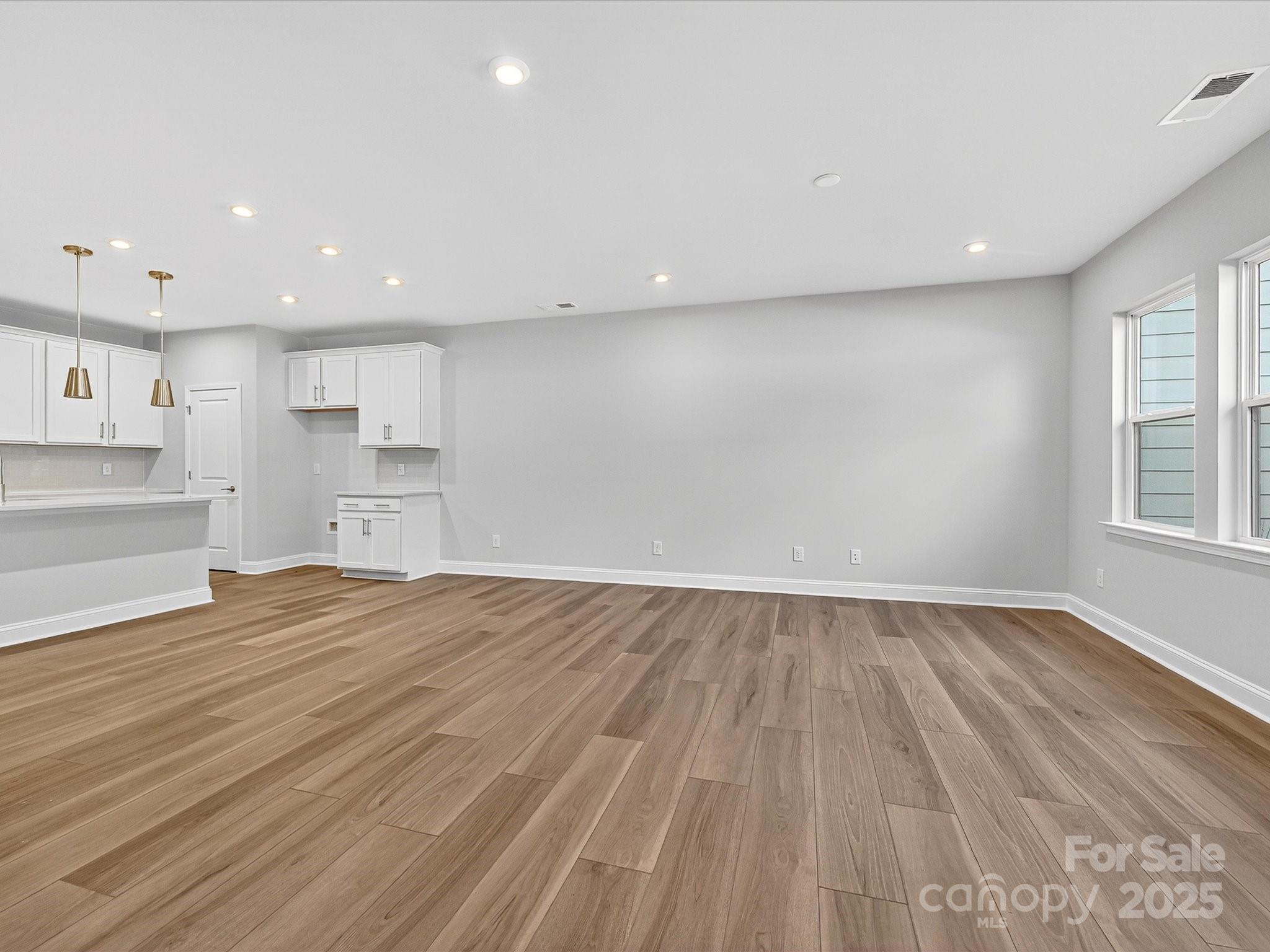 489 Nash Street Fort Mill, SC 29715 - Photo 3 of 24 an empty room with wooden floor and windows