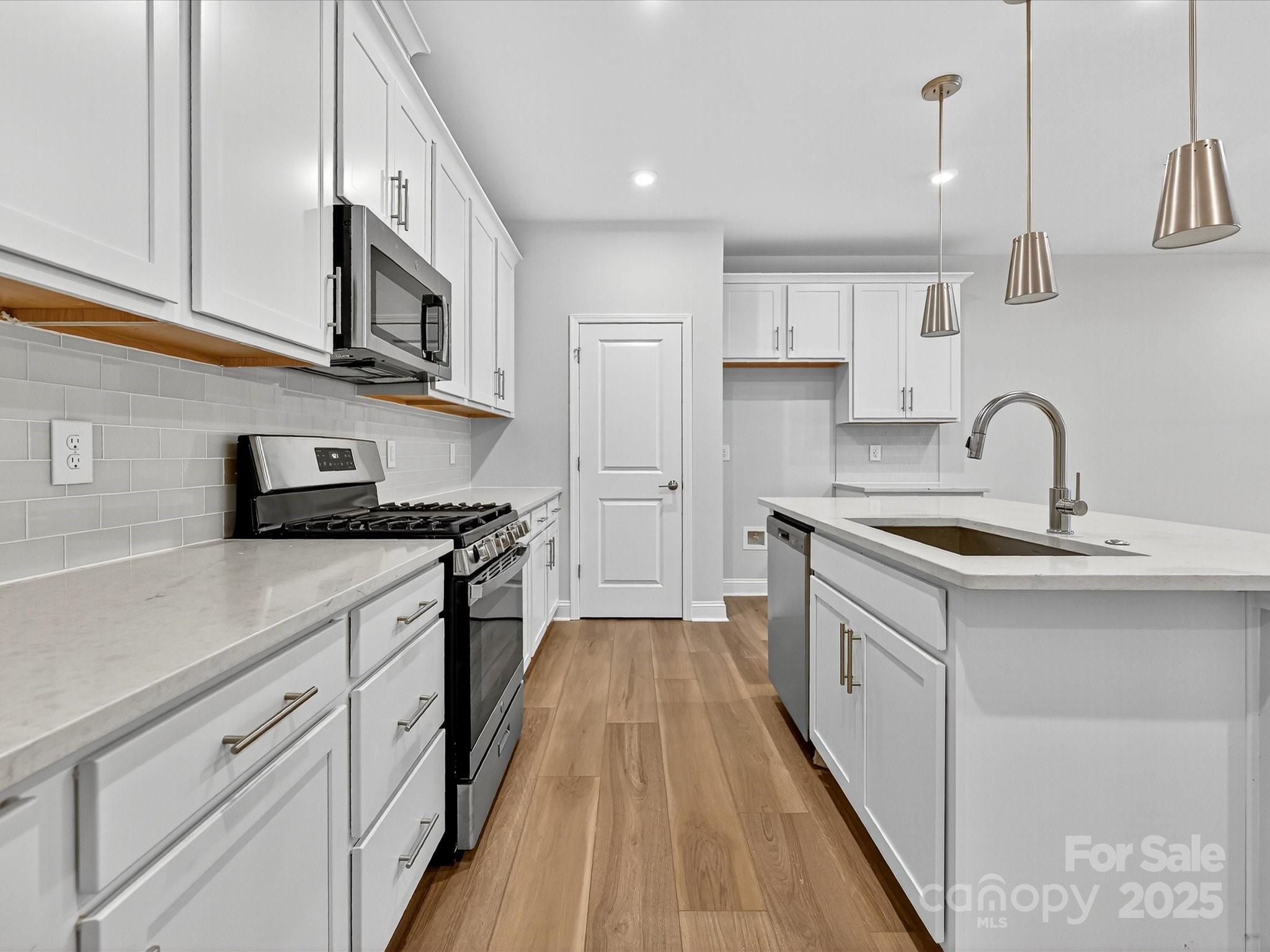 489 Nash Street Fort Mill, SC 29715 - Photo 5 of 24 a kitchen with white cabinets stainless steel appliances and a counter space