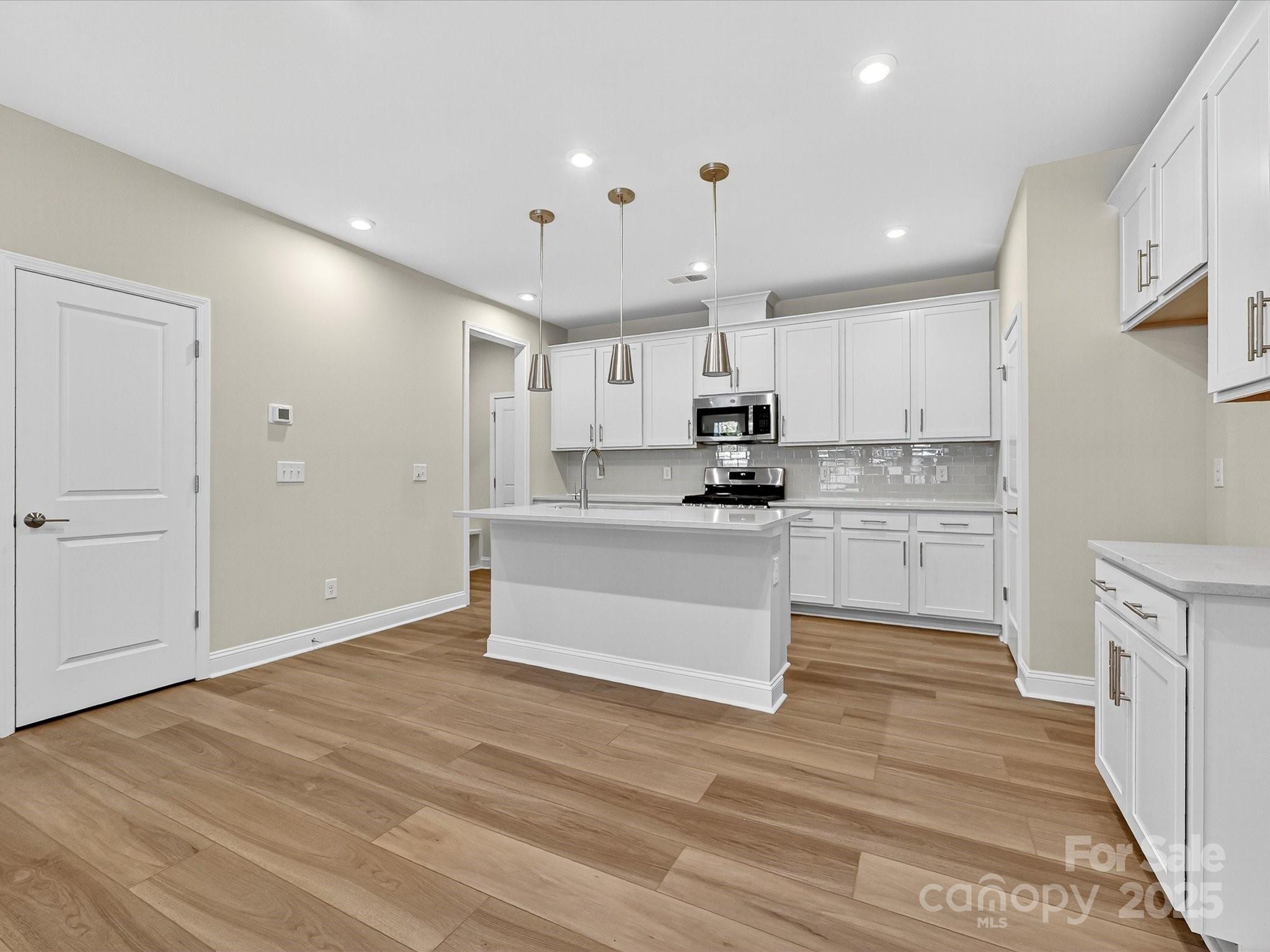 489 Nash Street Fort Mill, SC 29715 - Photo 6 of 24 a large kitchen with kitchen island a sink a center island stainless steel appliances and a cabinets