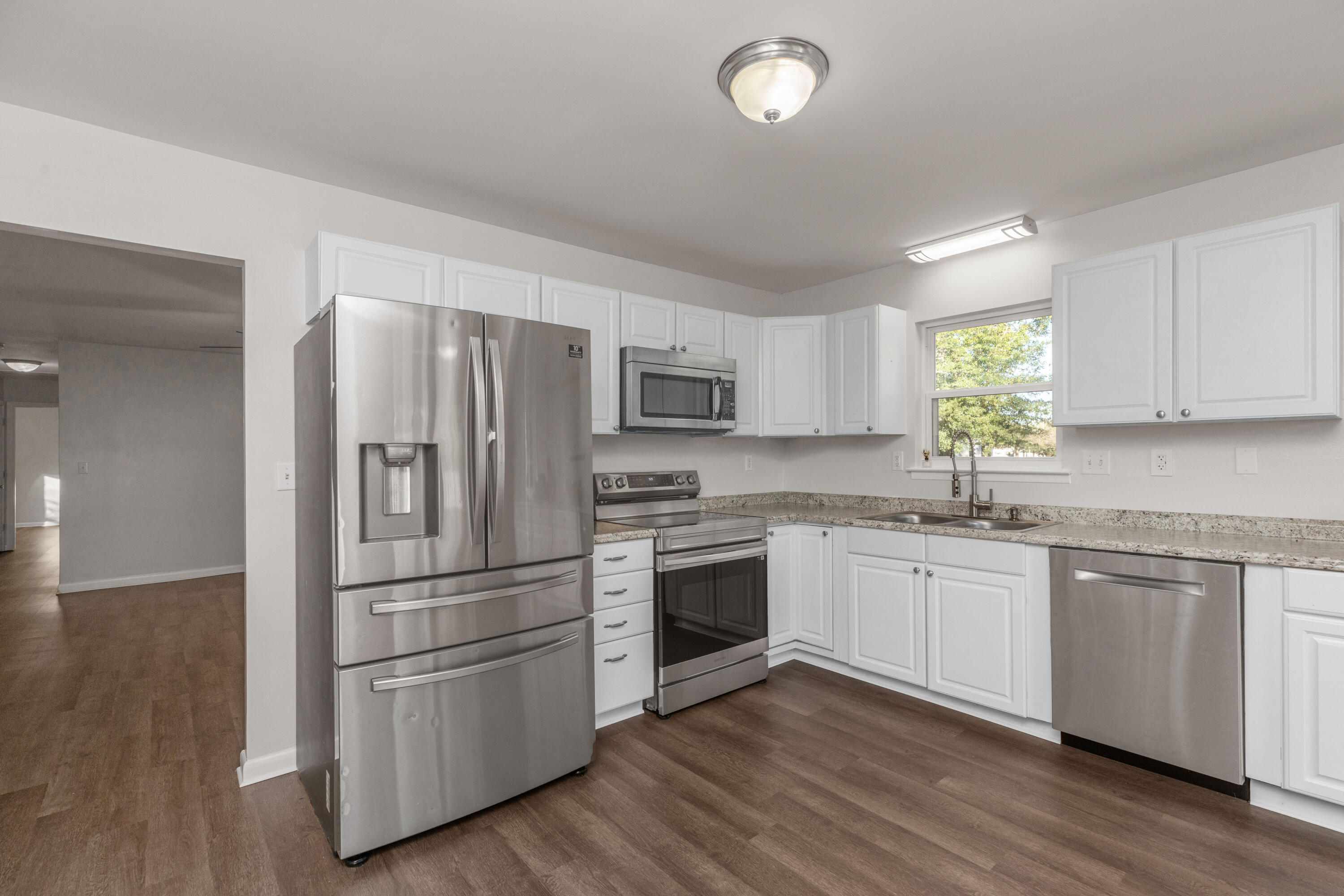 229 Madison Street Freeport, FL 32439 - Photo 14 of 44 a kitchen with granite countertop stainless steel appliances and wooden cabinets