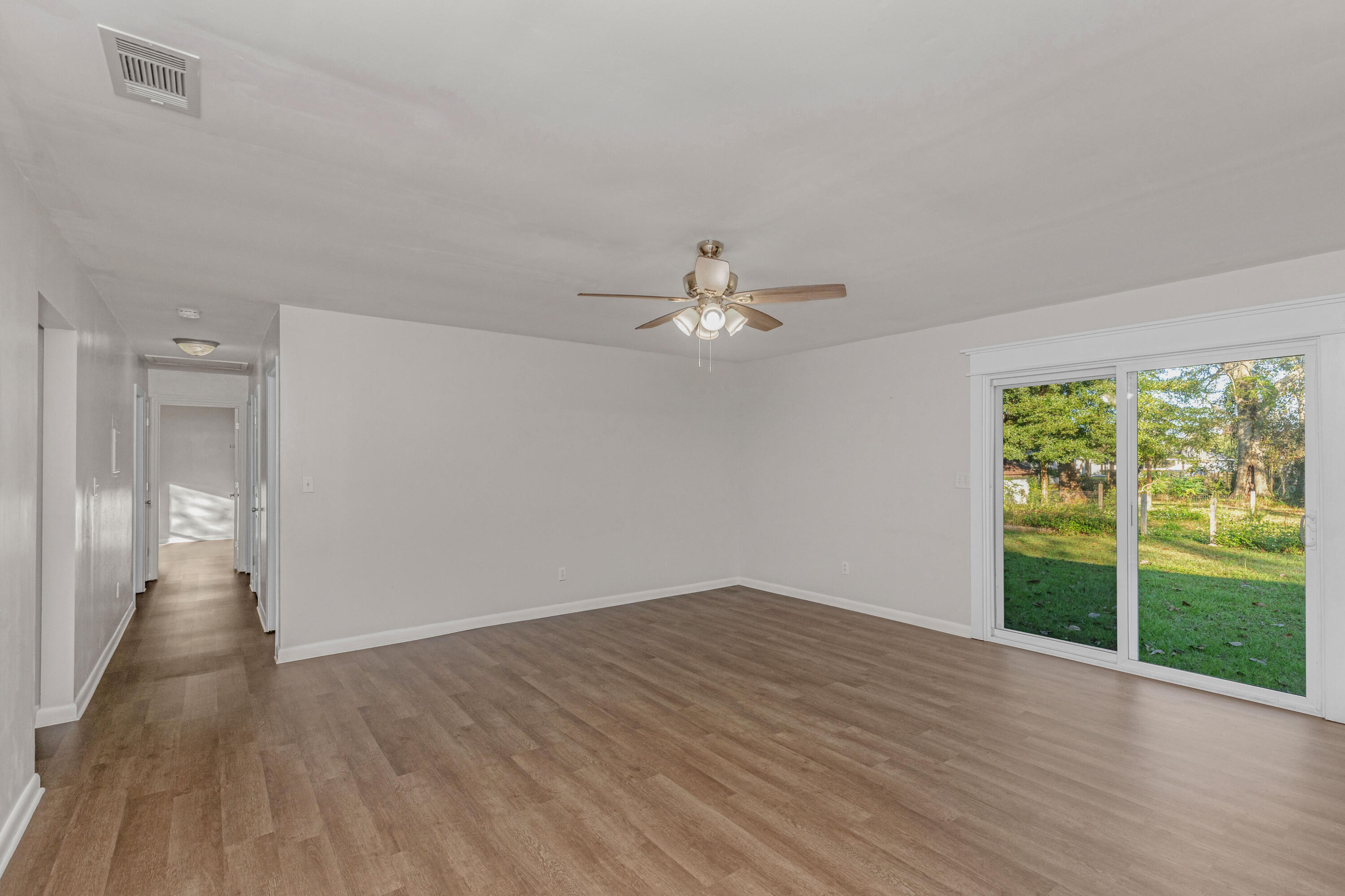 229 Madison Street Freeport, FL 32439 - Photo 18 of 44 wooden floor in an empty room with a window