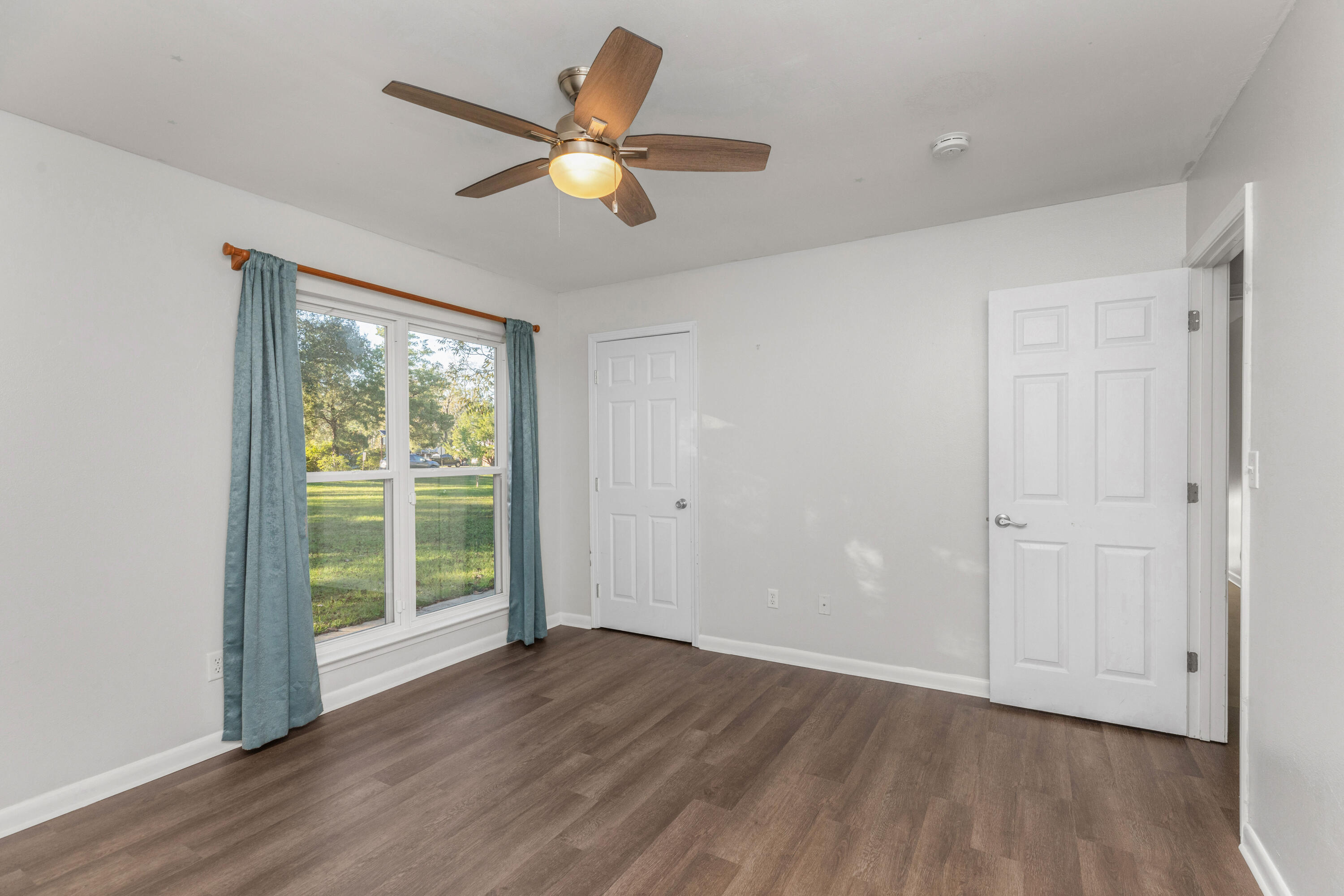 229 Madison Street Freeport, FL 32439 - Photo 22 of 44 an empty room with wooden floor and windows