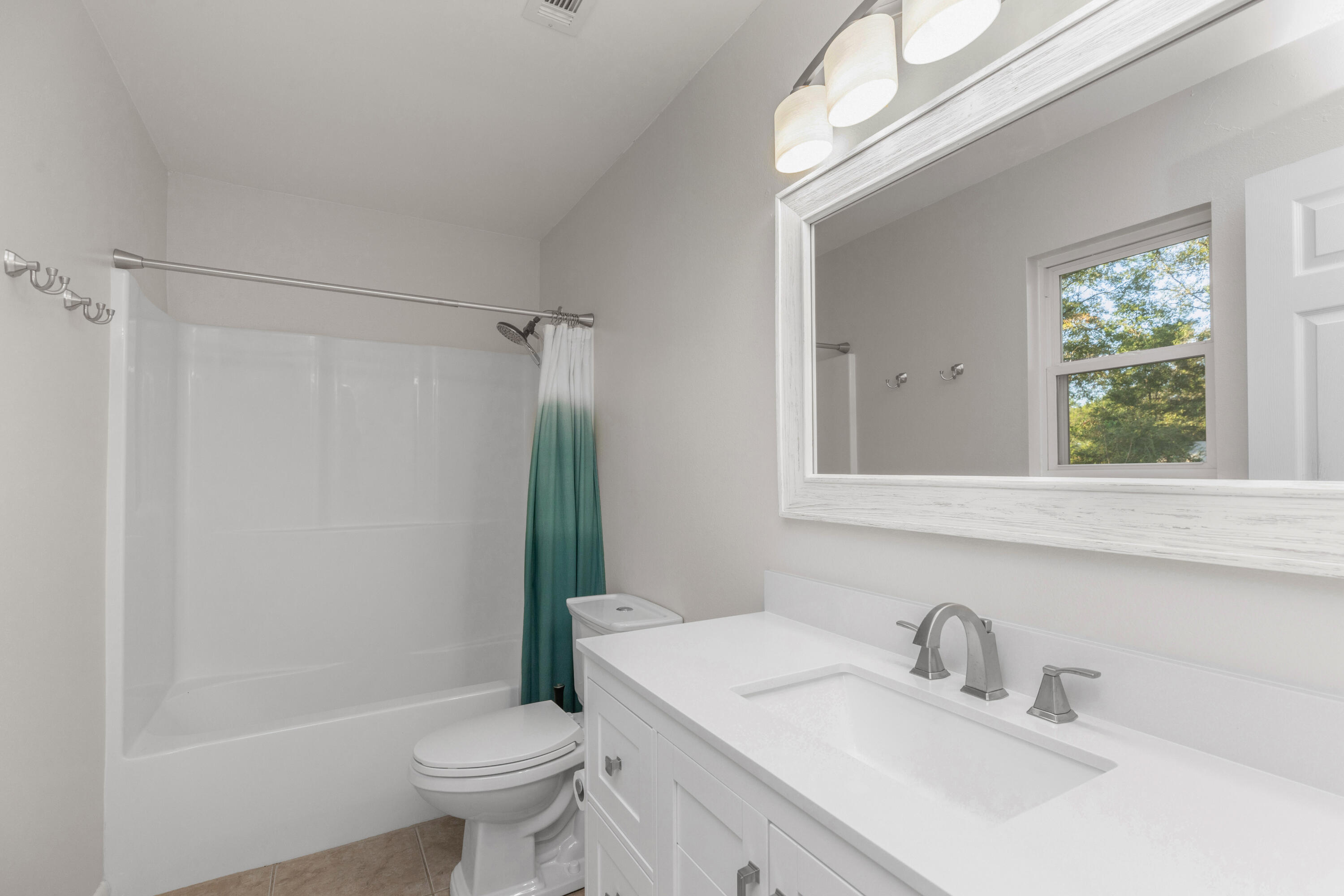 229 Madison Street Freeport, FL 32439 - Photo 31 of 44 a bathroom with a sink toilet and shower