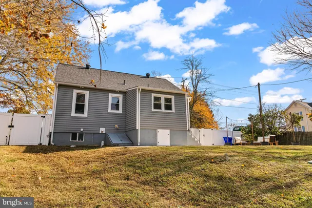 a front view of a house with a large tree in front