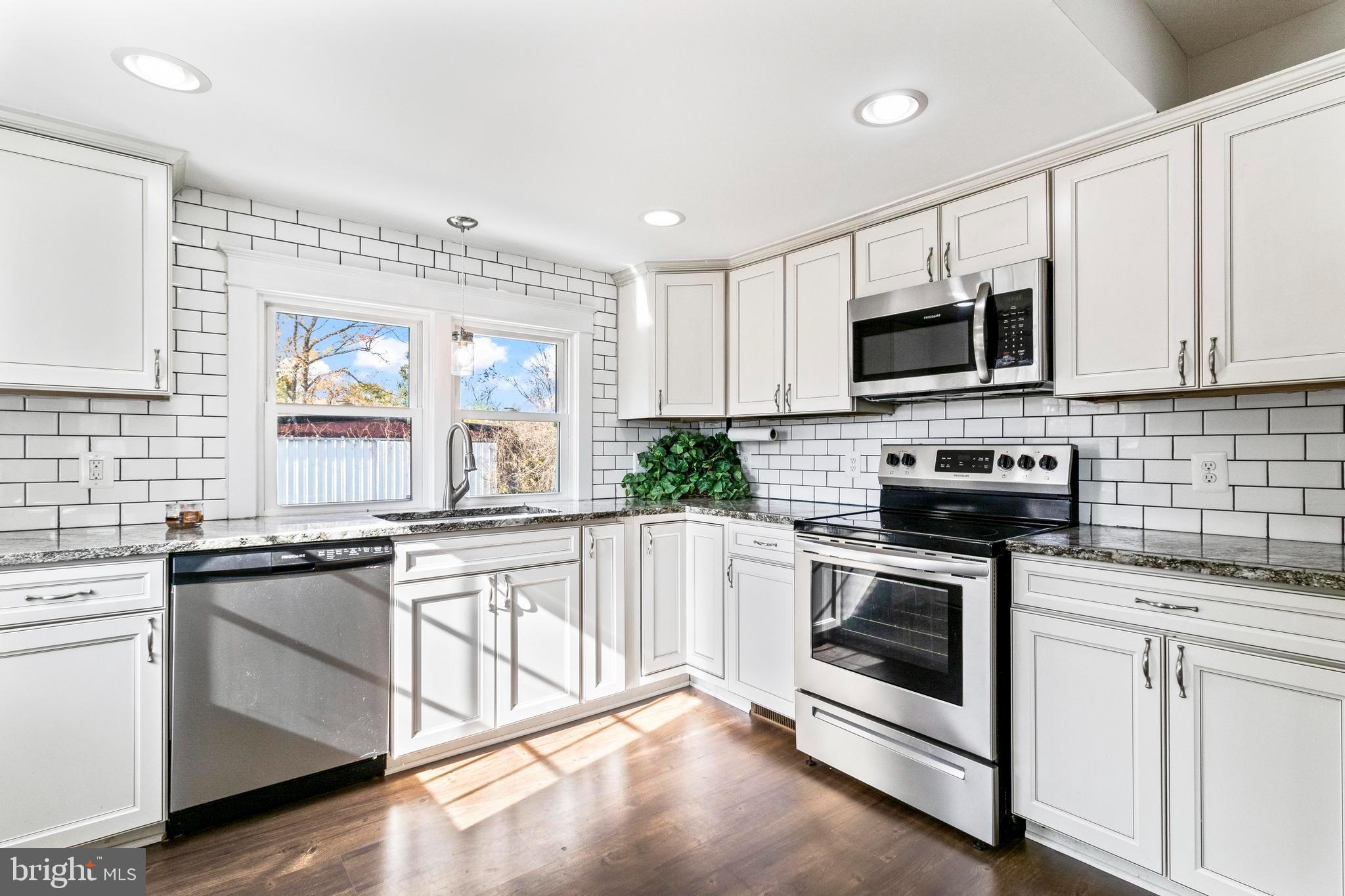 9005 Fairground Road Bel Alton, MD 20611 - Photo 9 of 54 a kitchen with granite countertop white cabinets white stainless steel appliances and a sink