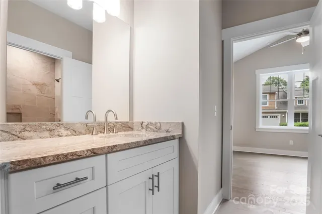 a bathroom with a granite countertop sink and a mirror