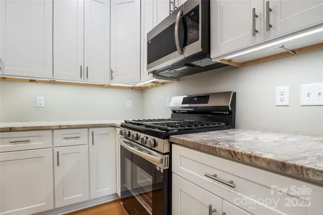 a kitchen with white cabinets and appliances