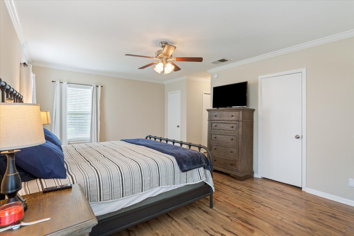 1607 North Harding Avenue Cameron, TX 76520 - Photo 18 of 37 A comfortable bedroom with rich wood flooring and crown molding offers a restful retreat.