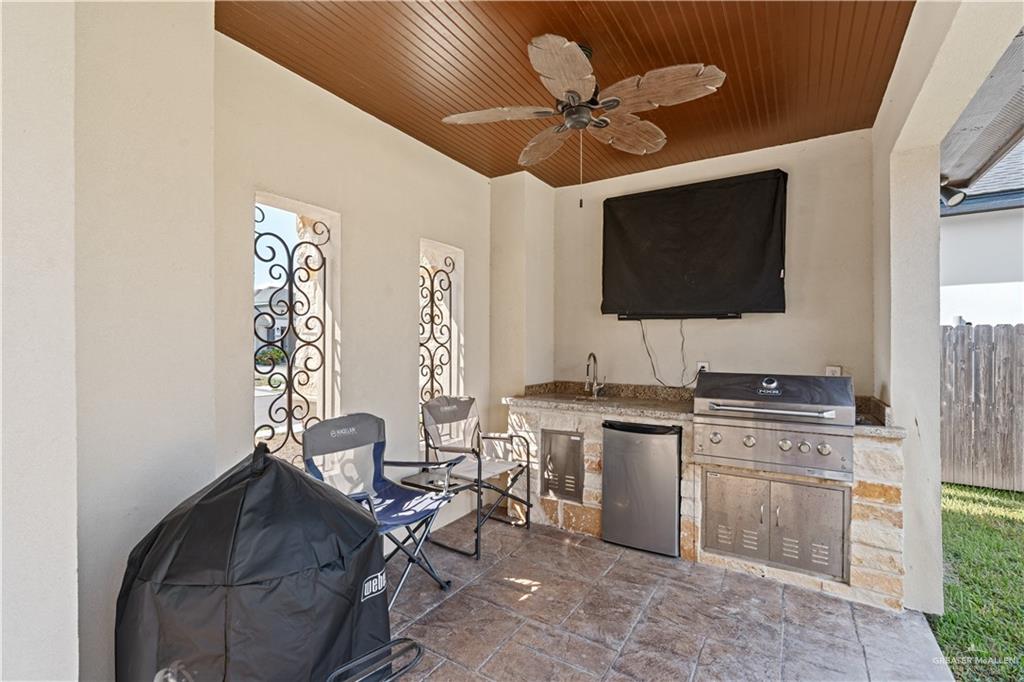 311 Seguin Loop Rio Grande City, TX 78582 - Photo 4 of 15 Outdoor kitchen featuring a built-in grill, sink, and under-counter refrigerator