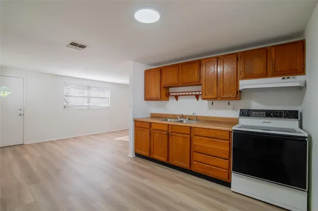 a kitchen that has a sink and a stove in it