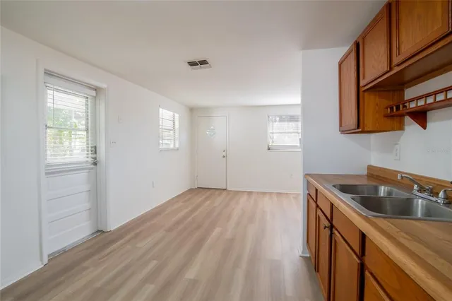 a kitchen with stainless steel appliances granite countertop a sink cabinets and wooden floor
