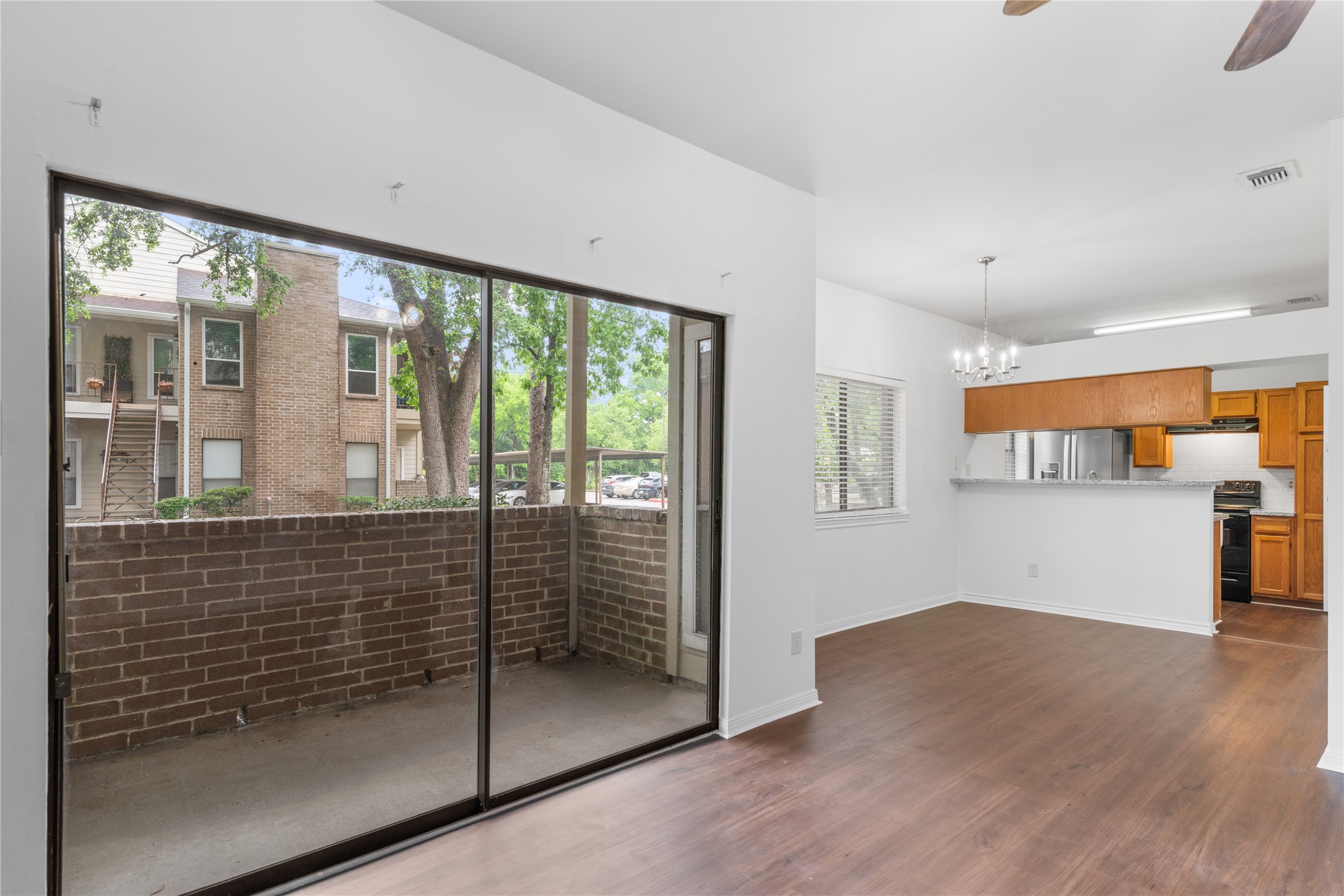 Vinyl plank hardwood floors! Large sliding glass doors lead to a private balcony with a view of the neighboring building and lush greenery.