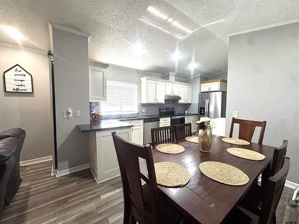 8261 County Road 381 Tyler, TX 75708 - Photo 27 of 40 a dining room with kitchen island granite countertop furniture and wooden floor