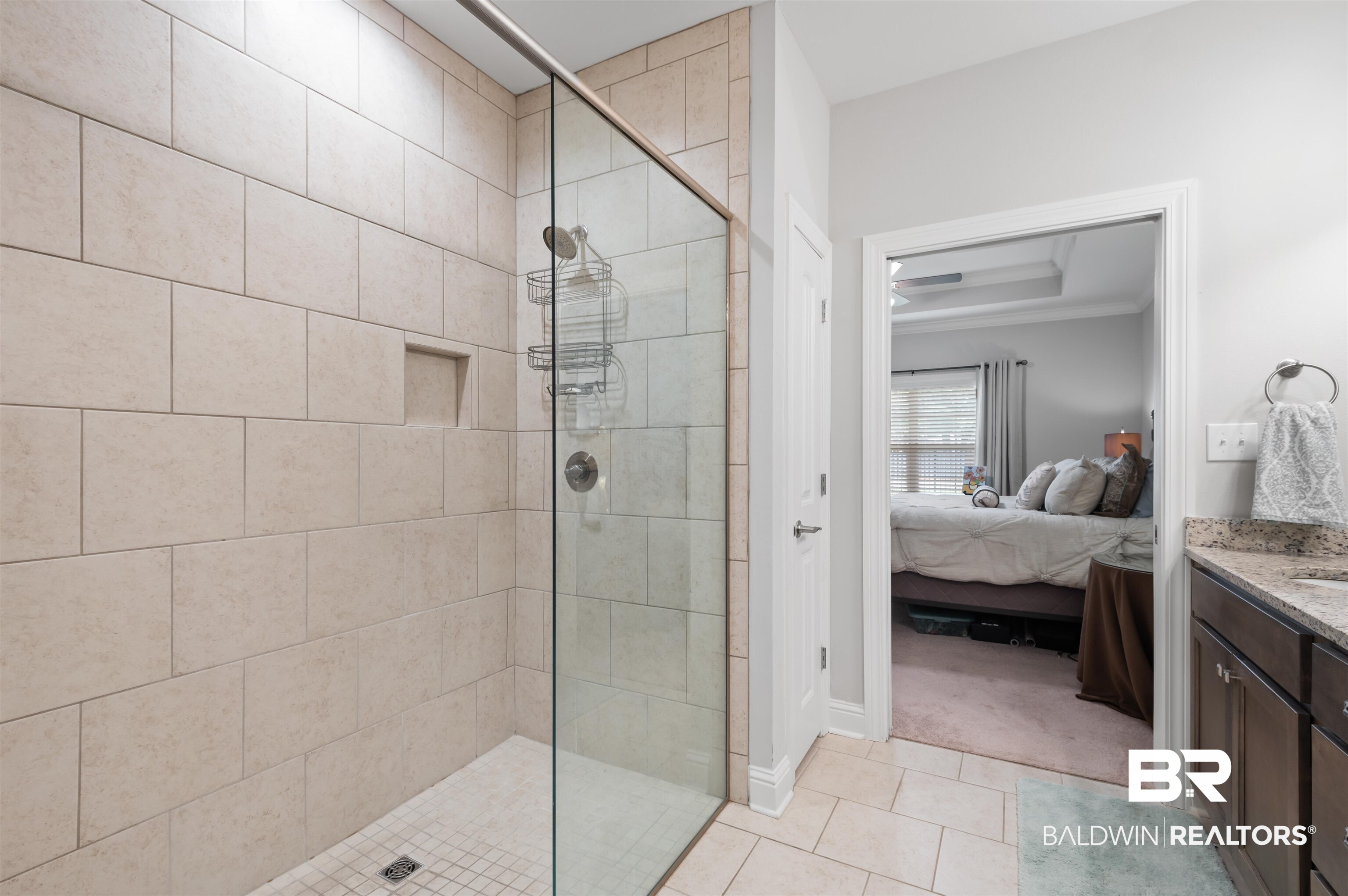 502 Holmes Avenue Foley, AL 36535 - Photo 25 of 41 Bathroom featuring tiled shower, vanity, and tile patterned floors
