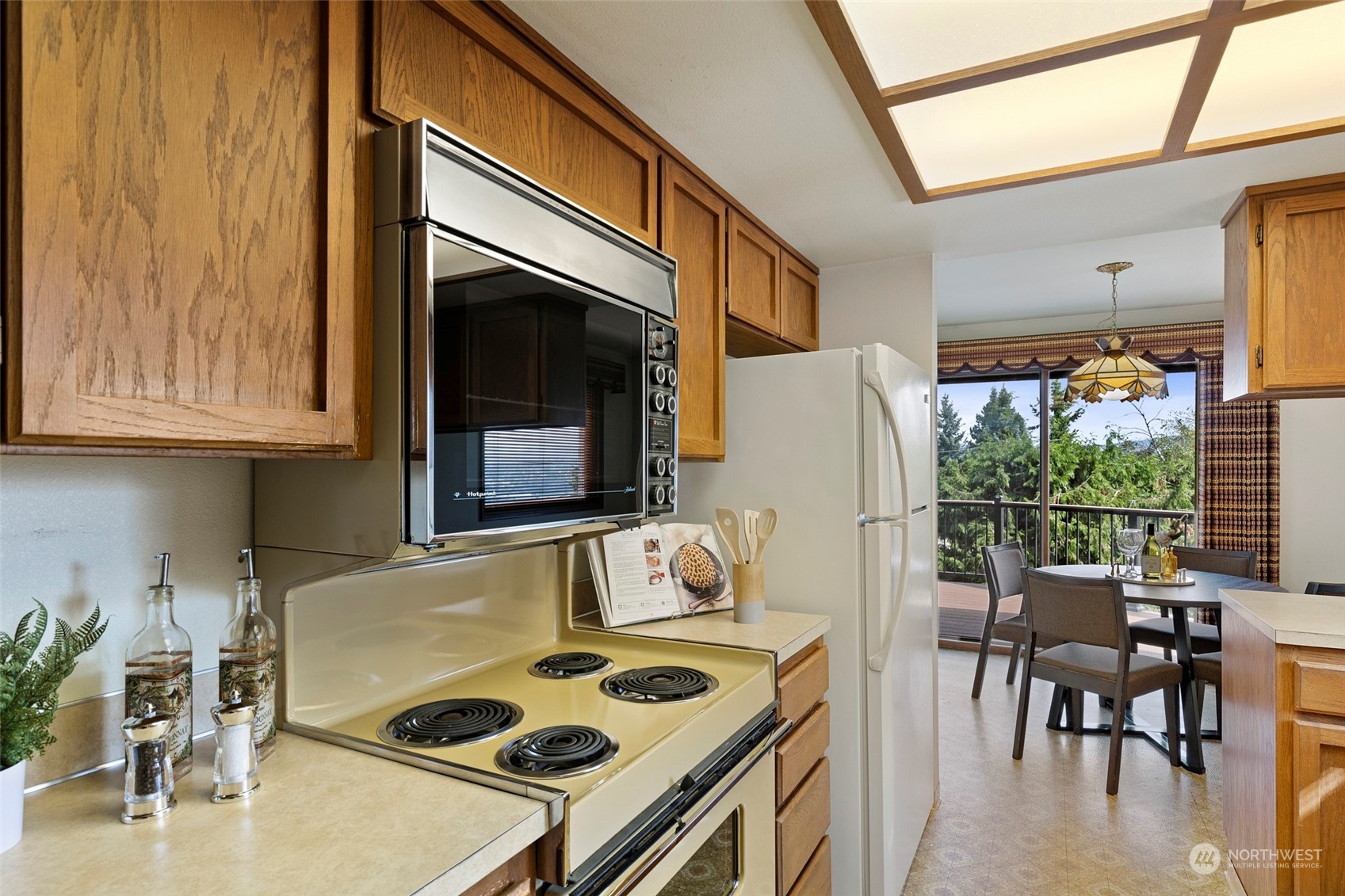 411 Seneca Court Northwest Renton, WA 98057 - Photo 12 of 37 a kitchen with a stove a refrigerator and a table