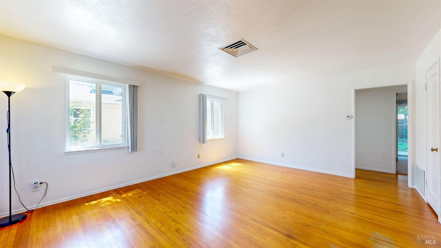 809 Maple Avenue Vallejo, CA 94591 - Photo 9 of 46 a view of an empty room with wooden floor and a window