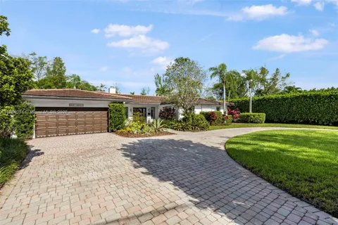 front view of a house with a large window and potted plants