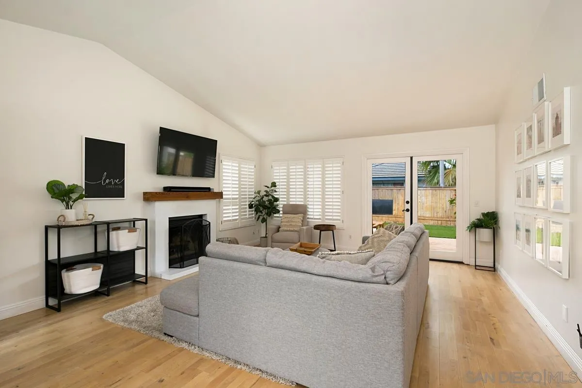 1265 Longfellow Road Vista, CA 92081 - Photo 16 of 28 a living room with furniture a fireplace and a flat screen tv