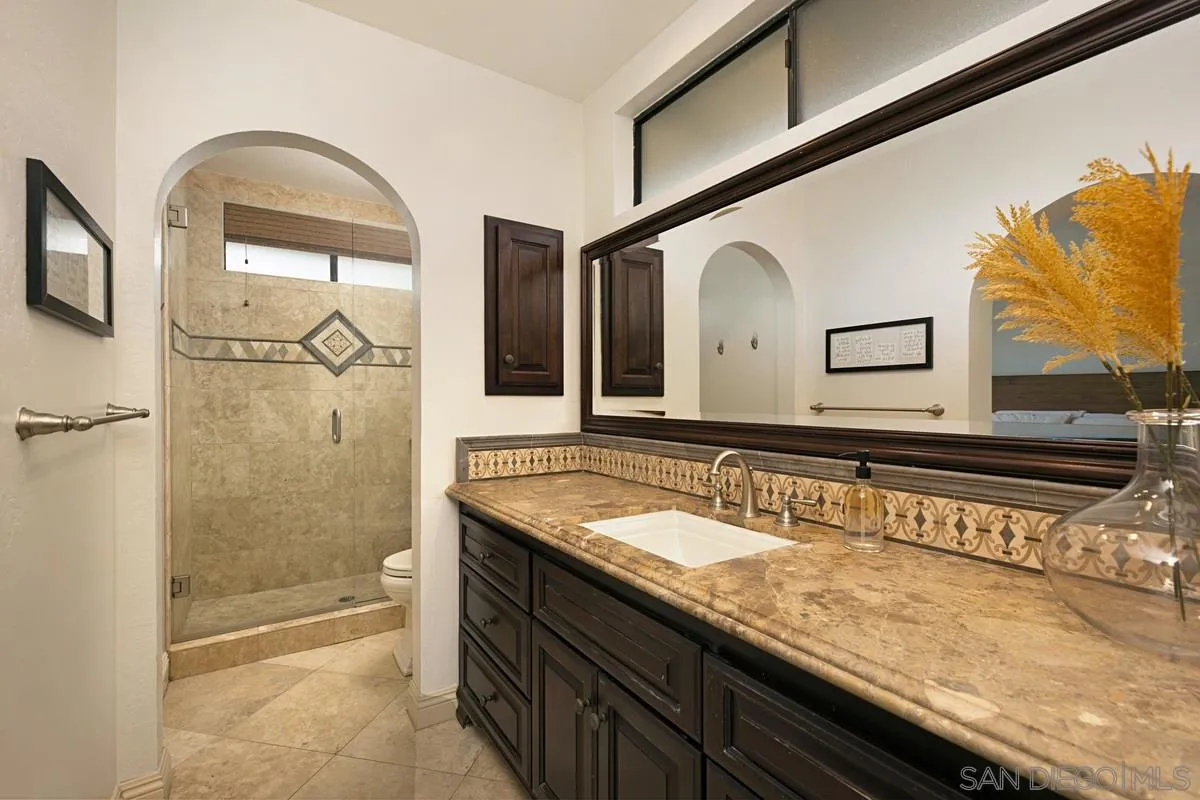 1265 Longfellow Road Vista, CA 92081 - Photo 19 of 28 a bathroom with a sink a mirror and a shower