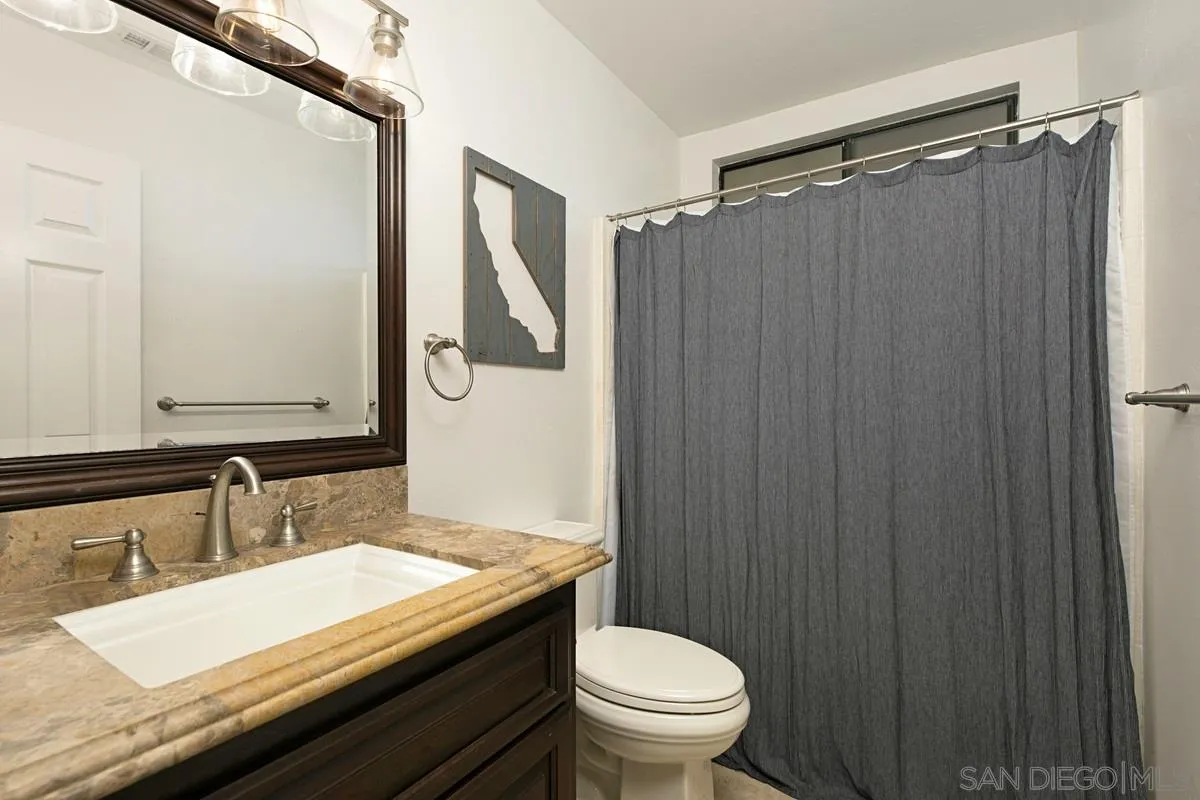 1265 Longfellow Road Vista, CA 92081 - Photo 23 of 28 a bathroom with a granite countertop sink toilet and shower