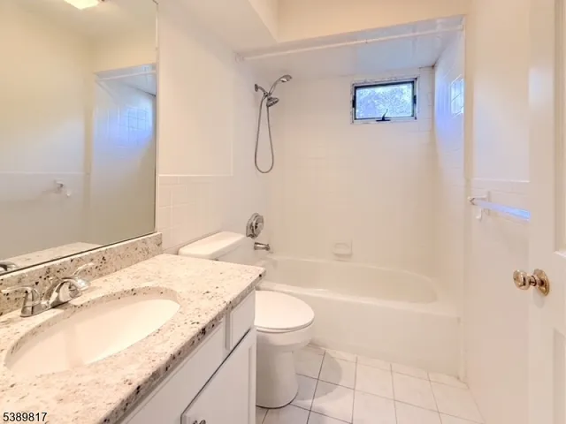 a bathroom with a granite countertop sink a toilet and bathtub