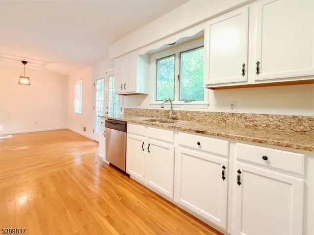 a kitchen with granite countertop white cabinets and white appliances
