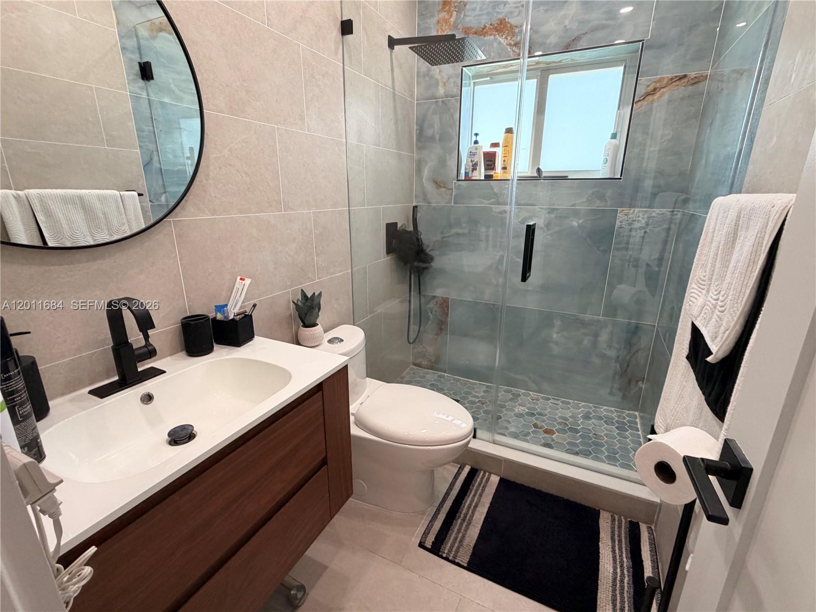 315 West 62nd Street Hialeah, FL 33012 - Photo 18 of 21 a bathroom with a sink a toilet and a mirror
