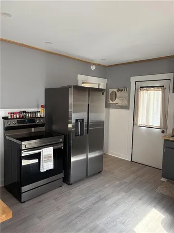 a kitchen with a refrigerator stove and wooden floor