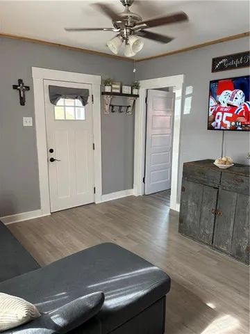 a view of a livingroom with wooden floor and a ceiling fan