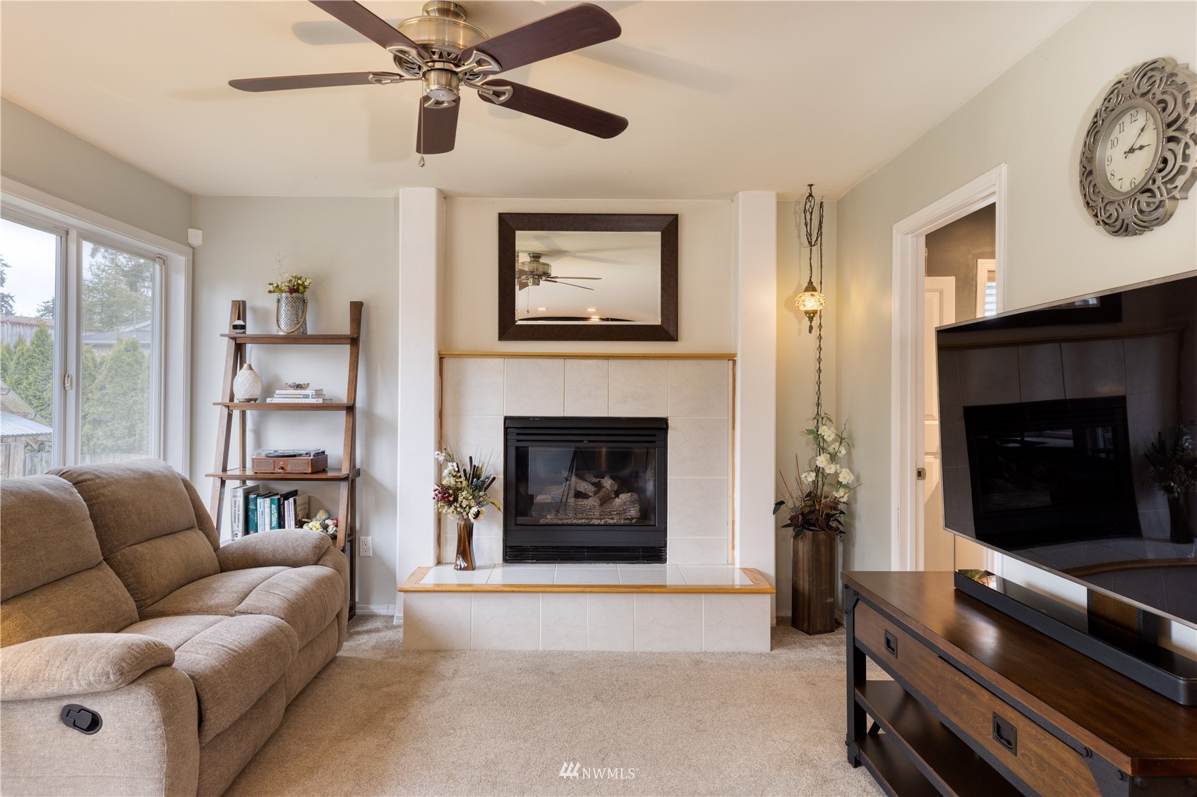 7414 Vandermark Road East Bonney Lake, WA 98391 - Photo 14 of 40 a living room with furniture a flat screen tv and a fireplace