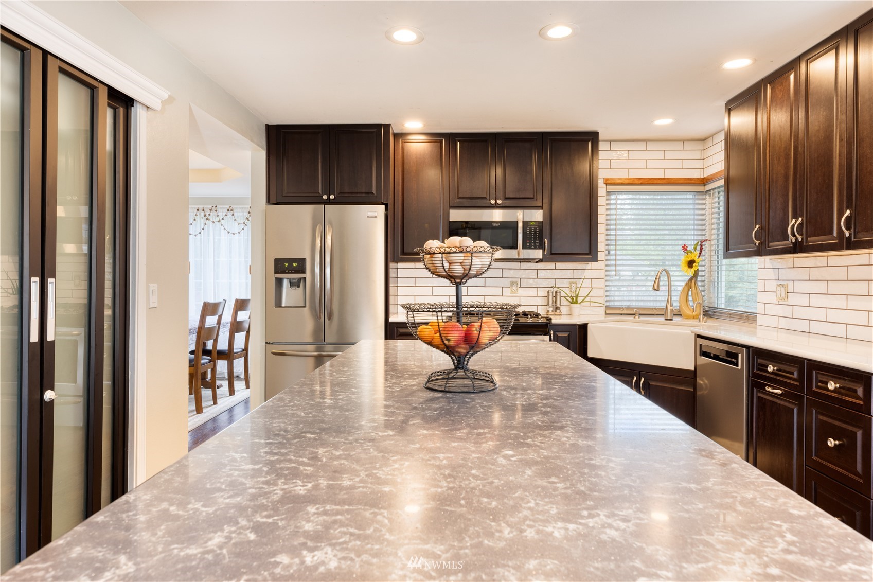 7414 Vandermark Road East Bonney Lake, WA 98391 - Photo 7 of 40 a large kitchen with stainless steel appliances kitchen island granite countertop a refrigerator and a sink