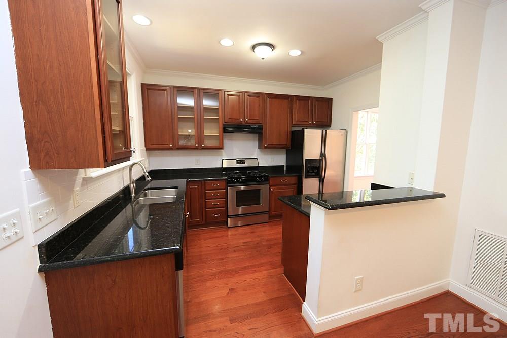 6111 Shandwick Court Raleigh, NC 27609 - Photo 5 of 17 a kitchen with stainless steel appliances granite countertop a sink a stove and a refrigerator