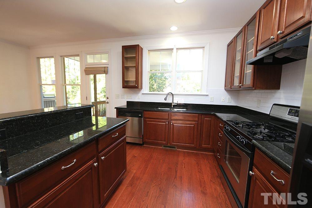 6111 Shandwick Court Raleigh, NC 27609 - Photo 6 of 17 a kitchen with granite countertop a sink a counter space appliances and cabinets