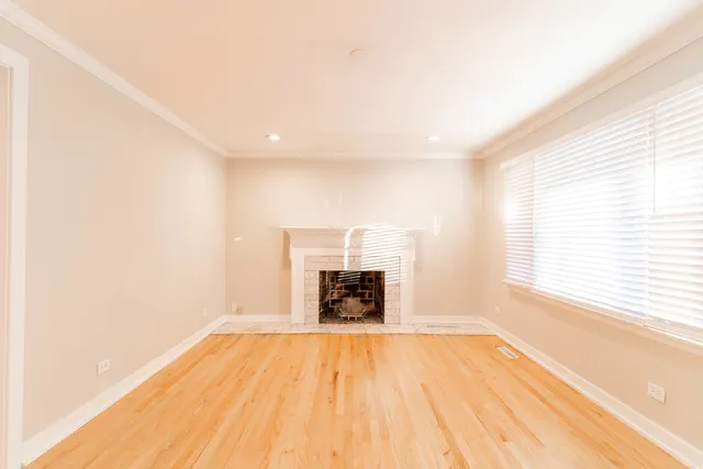 a large kitchen with granite countertop a refrigerator oven a sink dishwasher and white cabinets with wooden floor