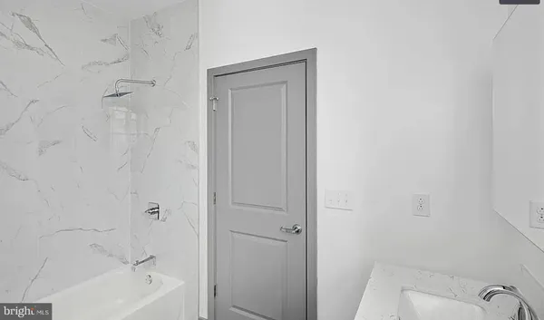 a bathroom with a tub shower and sink