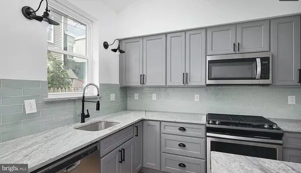 a kitchen with granite countertop white cabinets white stainless steel appliances and a sink