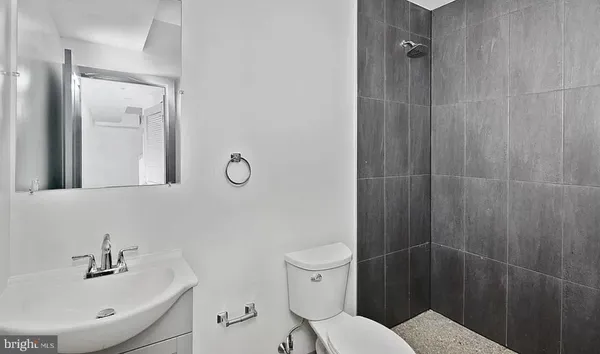 a bathroom with a toilet shower vanity and a sink