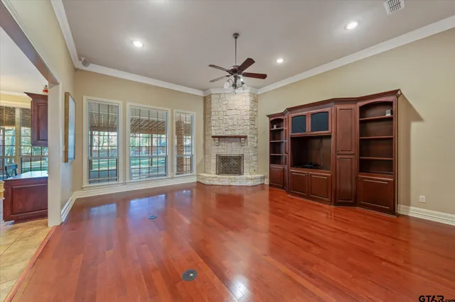 a view of empty room with wooden floor and fireplace