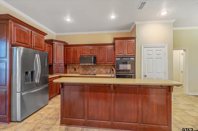 a kitchen with stainless steel appliances granite countertop a refrigerator and a stove