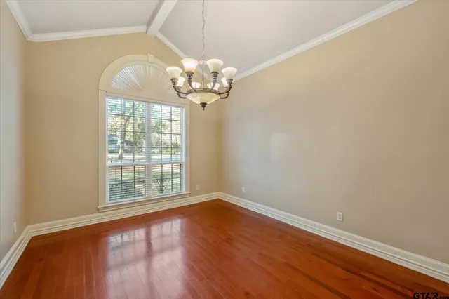 a view of a big room with wooden floor and chandelier
