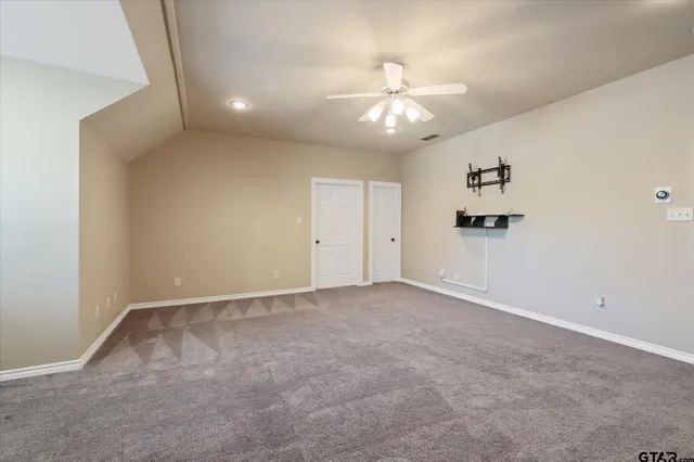 an empty room with fan and windows