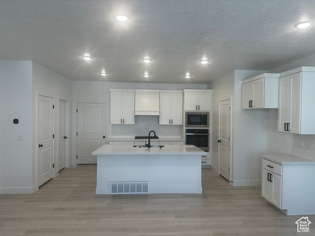 80 South Moonlit Road Mapleton, UT 84664 - Photo 3 of 18 Kitchen with white cabinetry, decorative backsplash, stainless steel appliances, light stone counters, and a textured ceiling